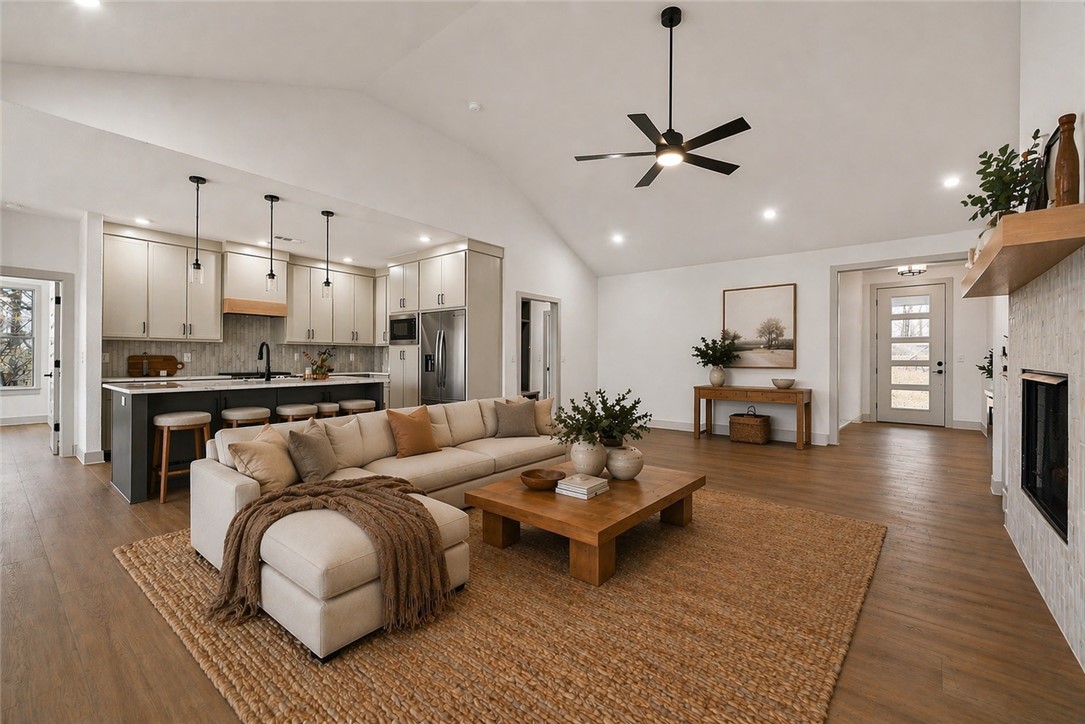 Stunning modern luxury new construction with breathtaking Ozark views! Near Loch Lomond and just 1 mile from Tiree Park & boat dock. This thoughtfully designed single-level home features soaring cathedral ceilings, luxury vinyl plank flooring, premium finishes, and oversized windows that flood the open-concept living area with natural light. The chef's kitchen boasts a massive island, quartz countertops, custom cabinetry, and a walk-in pantry. Split floor plan with 3 bedrooms, 2 baths, plus a dedicated office with built-ins. The private primary suite offers a spa-inspired bath with a soaking tub, custom tiled shower, and spacious walk-in closet. Relax on the large covered deck while enjoying panoramic Ozark views. Oversized 2-car garage with built-in cabinetry. Enjoy easy access to boating, fishing, kayaking, golf, hiking, and Bella Vista's renowned trail system—all just minutes from your front door. Luxury, comfort, and an unbeatable location!