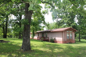Perfect lake retreat! This home is about 5 minutes from Tucker Hollow Marina and with a little work, it would be the perfect spot for a weekend lake getaway! Beautiful park-like 3.29 acres with large trees, pond, and some wooded acreage! You could either fix this little mobile up or remove the mobile and build your dream home on this wonderful land! Nice, quiet setting with a back deck overlooking the acreage! There is a carport and a shed with a 1/2 bath and ''man cave'' area, and a lean to off the side. So many possibilities with this property!