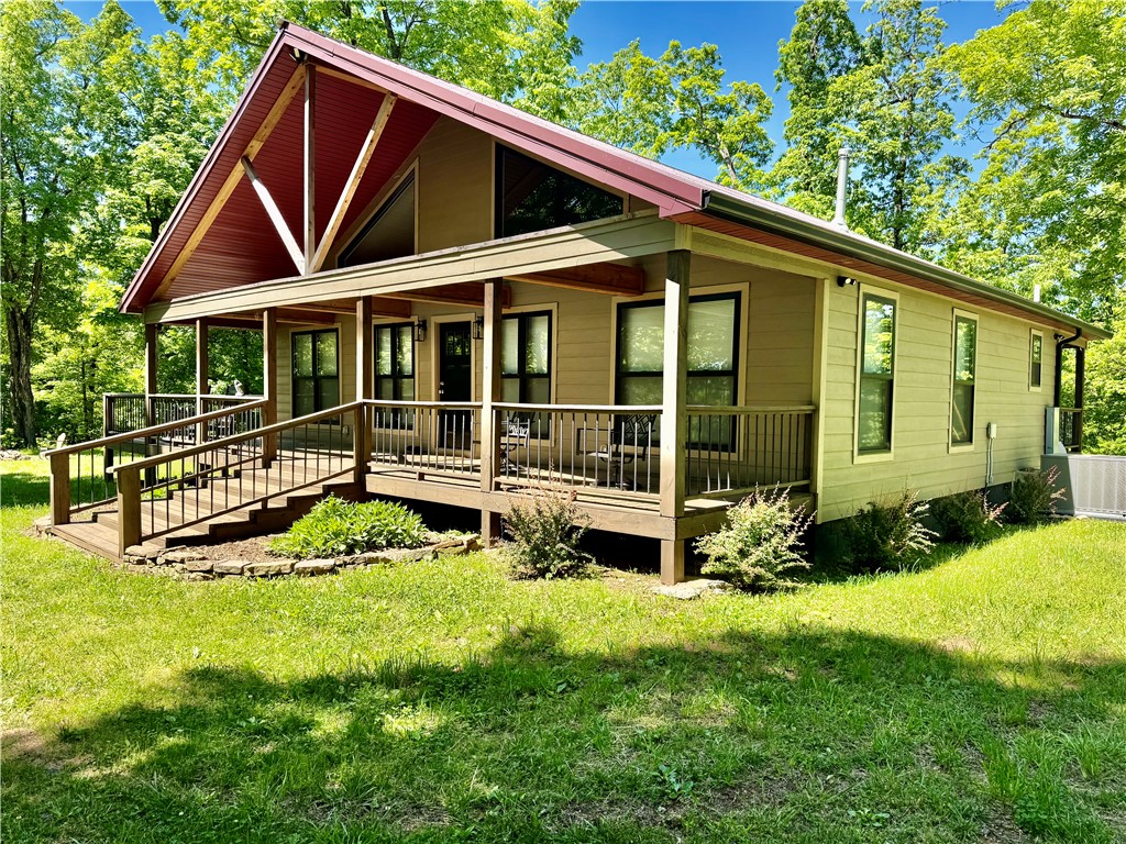 Custom-built furnished cabin near Pettigrew, AR, with gated access and direct access to the Ozark-St. Francis National Forest. Features include an open floor plan, vaulted ceilings, a wraparound porch, high-speed internet, a rainwater collection system, a storage container with a lean-to, a trail system, and recreational opportunities for hunting, ATV riding, and outdoor use.