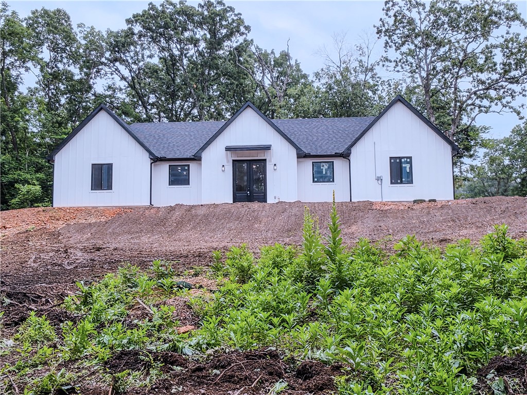 MOTIVATED SELLER! New-construction modern farmhouse in Bella Vista—3BR/2BA, 2,135 SF on one level, built with Nudura ICF (Insulated Concrete Form) construction by a builder with 30+ years of experience. ICF replaces wood framing with reinforced concrete walls wrapped in continuous insulation—a measurably stronger, quieter, more efficient home with steady indoor temperatures year-round and lower heating and cooling costs for the life of the structure. Open great room and kitchen, large pantry, true mudroom, and dedicated laundry. Private primary suite with walk-in closet and spa-style bath; two additional bedrooms and a second full bath. High-grade laminate flooring, granite countertops, and GE Professional appliances throughout. Sited at the end of a private cul-de-sac with a side-load garage. Bella Vista delivers seven lakes, golf, and 100+ miles of trails, minutes from Bentonville's employment and cultural anchors. New single-level construction of this quality is scarce here. Motivated seller; immediate occupancy