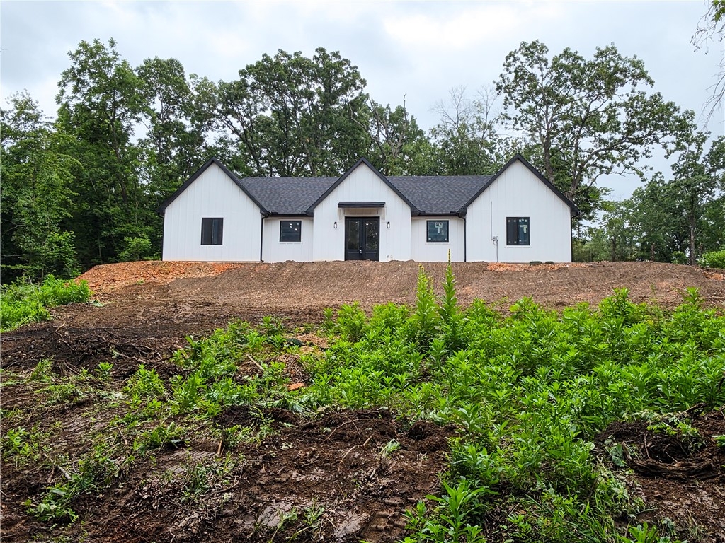 MOTIVATED SELLER! New-construction modern farmhouse in Bella Vista—3BR/2BA, 2,135 SF on one level, built with Nudura ICF (Insulated Concrete Form) construction by a builder with 30+ years of experience. ICF replaces wood framing with reinforced concrete walls wrapped in continuous insulation—a measurably stronger, quieter, more efficient home with steady indoor temperatures year-round and lower heating and cooling costs for the life of the structure. Open great room and kitchen, large pantry, true mudroom, and dedicated laundry. Private primary suite with walk-in closet and spa-style bath; two additional bedrooms and a second full bath. High-grade laminate flooring, granite countertops, and GE Professional appliances throughout. Sited at the end of a private cul-de-sac with a side-load garage. Bella Vista delivers seven lakes, golf, and 100+ miles of trails, minutes from Bentonville's employment and cultural anchors. New single-level construction of this quality is scarce here. Motivated seller; immediate occupancy