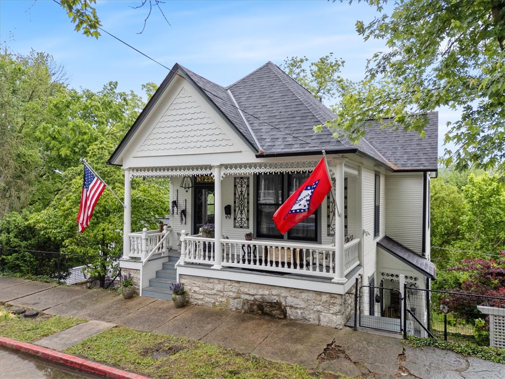 Lovely Historic home CIRCA 1920 in downtown Eureka Springs. Beautifully remodeled with luxurious upgrades to the main floor primary bedroom & en suite bathroom with huge new walk in closet. This home is in the perfect location on two big lots on upper Spring Street, just a couple blocks north of downtown. The additional lot is perfect for outdoor entertaining & lush gardens while it also allows the new owners the opportunity and possibility to build a garage with guest house. The floor plan is quite unique with two large living areas, one on each floor. The lower level has a bright & airy kitchen with breakfast nook, center island and pantry. Large formal dining room with stained glass bay windows and an exceptional view! There are 2 full baths, one with full size laundry area & 2 bedrooms on this floor as well. Lower level family room opens up to a private & expansive deck as well as a "secret garden" & a second outdoor seating area for morning coffee on the quaint stone patio and side garden just off the kitchen.