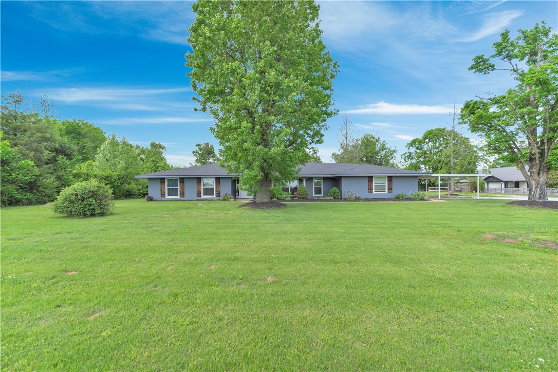 Looking for a house with flat land in the middle of town with no deed restrictions? Look no more, located next to Mountie Bike Trail and close to Rogers High School. Ranch style home with tons of updates, beautiful front covered porch , new luxury vinyl flooring throughout, spacious kitchen with granite counter tops and modern backsplash, range hood vent, formal dining area with fireplace, spacious living area with tons of windows for natural light, updated main bathroom with soaking tub, spacious 4th bedroom/bonus room, new roof and newer HVAC, large shop, large covered back patio with extended pergola to entertain your guests.