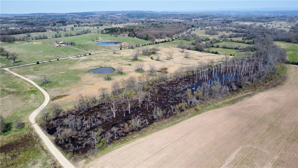 Opportunity to own +/- 7.7 acres of highway-front pastureland just south of Webb City, AR. Build your dream home and enjoy peaceful country living just minutes from the Arkansas River. The property measures approximately 275 feet wide by 1,230 feet long, with Highway 309 bordering the west side and the slough forming the eastern boundary. The land is level and offers access to power along the highway. Conveniently located just minutes from downtown Ozark. Tract 1, (+/- 7.5) located directly north of the property is also available. Buyer is responsible for inspecting access to utilities.