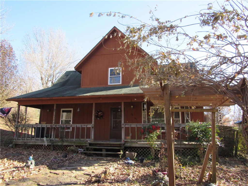 Easy drive from downtown Fayetteville, just 3 miles from Greeenland exit, this lovely country home on a paved road has wooded privacy in the rear.  Lots of character, & plenty of room for relaxing with a large covered porch, patio and a balcony sitting area off the MBR. View of distant hills.  MBR has 2 walk-in closets & a reading nook/office area. Updated flooring. Energy efficient vinyl windows added in 2012, HVAC replaced in '09.  Large fenced yard, 2 storage buildings. One year home warranty included