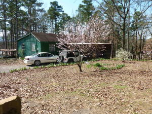 Over 5 acres bordering timber company land offers hunting and fishing in stocked pond. 2 BD, 1 BA home also has 30 x 57 shop with half bath, barn, wood shed, out building...all with electricity. Gazebo also. Partially fenced for horse. Screened in porches on front and back. Looking to move to the country or for a hunting get away? Give this one a look. Property will be surveyed out of 17 acres. Current tax parcel includes 17 acres and additional house.