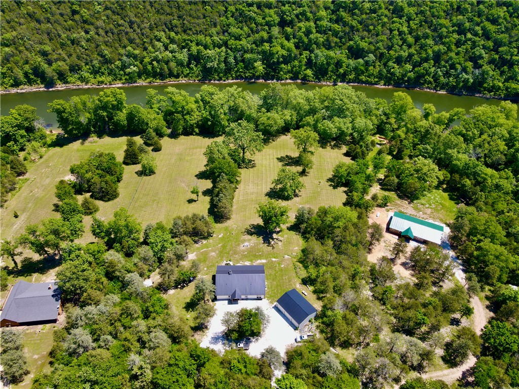 This 6.4+/- acres sits on the famed White River offering a blend of modern construction, usable land, and premier water frontage. With 470 ft. of river frontage that's known for its trout/walleye fishing and kayaking. The land has pasture, ideal for hobby farming or recreation and timber between the home and the road providing privacy. Built in 2023, the custom 1,920 square foot home was designed to maximize comfort and style. Inside, you’ll find 3 bedrooms and 2 bathrooms beneath soaring 22-foot vaulted ceilings that create an open, airy feel. Quartz countertops run throughout the home, complementing a well designed layout to include a spacious primary suite with an oversized closet. The laundry room even features a built-in dog wash, adding convenience for outdoor living. A screened sitting area and open-air porch provide vantage points to take in the surrounding mountain views and river atmosphere. There's a 1,200 square foot metal building with 3 bay doors and 8 minutes to Beaver Dam and White River boat ramp