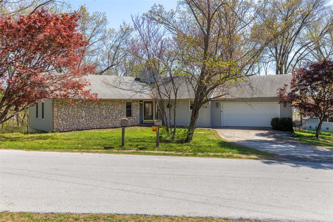Welcome home to this charming 3/2 in a quiet Bella Vista tree-lined neighborhood. Remodeled around 2015 with a new roof, composite deck, HVAC, and oak-trimmed new windows. Enjoy the views from the enclosed sunroom or make the walk-out basement your hobby room or guest quarters. Beautiful oak cabinets and shelving grace the roomy eat-in kitchen, and a floor-to-ceiling stone fireplace makes the living room warm and cozy.  Flat front yard with a gently sloped backyard. Great for kids or gardeners. To be sold AS IS.