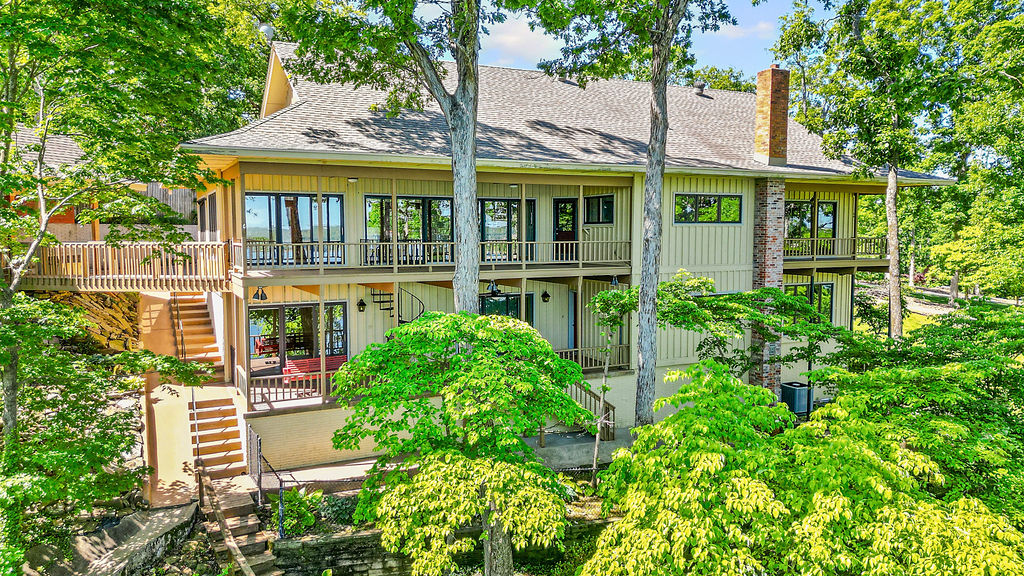 Incomparable Beaver Lakefront home with two boat slips included on a community 4-slip dock, easy access to the water for endless days of boating, fishing, and relaxation. 3 bed, 3.5 bath 4500sqft home is filled with windows that showcase stunning lake views from Every room in the house! Two covered decks provide the perfect setting to unwind, entertain, or simply take in the peaceful surroundings. Downstairs offers exceptional flexibility with two bedrooms connected by a jack-and-jill bath, a spacious game room, and a multipurpose room ideal for craft/hobby room, or additional bedroom. A large storage shed along the path to the lake adds storage for toys, complete with a 4’x8’ covered patio overlooking the water. Whether you’re looking for a full-time residence or a weekend retreat, this is the perfect lake retreat.  Only 27min from Walmart Campus or Pinnacle Area, 13min to Downtown Rogers.