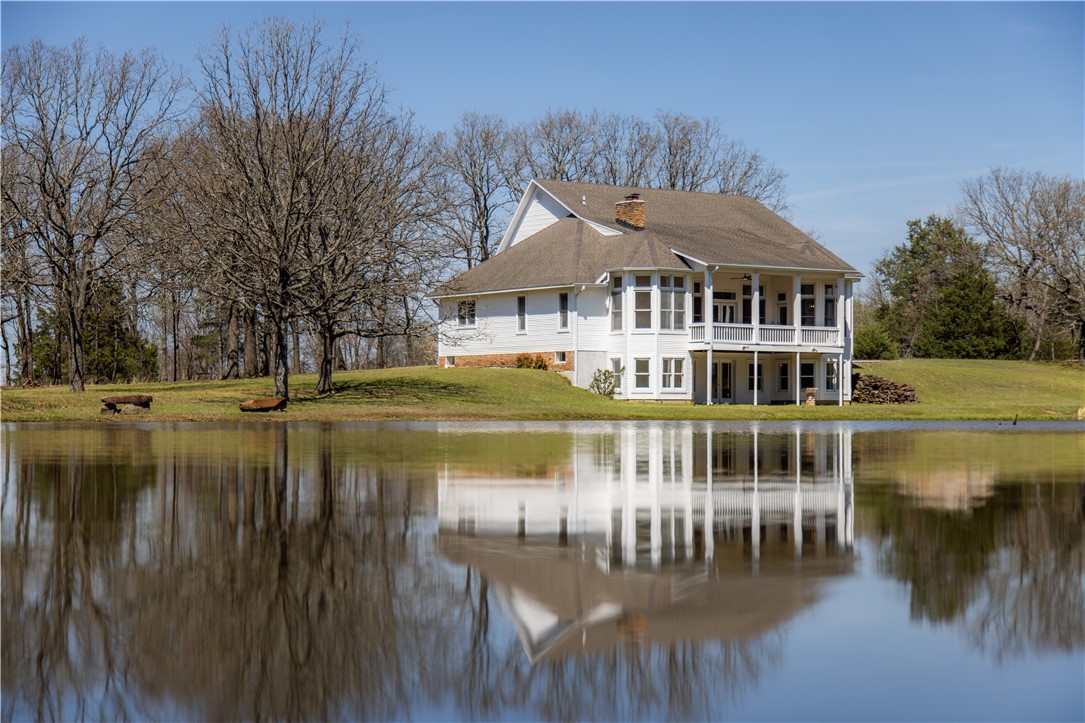 This charming 6 bed, 5.5 bath New England style home is set on 4.45-acres tucked away in the Prairie Grove hillside. This estate features a stocked bass pond that serves as the centerpiece of your private oasis. Newly updated in March '26, boasting new paint, carpet, light fixtures, countertops, contemporary hardware & a newly poured concrete slab. Inside, the character of this home is one-of-a-kind with original wide cedar plank flooring that pairs beautifully with the wood fireplace in the living room. The large windows fill each room with natural light & provide views of the rolling landscape. Downstairs enjoy the wood-burning stove in the additional living room. The home is equipped with a geothermal heating system. Retreat to the two-story back porch to enjoy your view of the water & surrounding landscape. Seller is offering a $2k appliance credit and a $3k credit for kitchen cabinet refinishing. This property is a rare opportunity to enjoy a classic, updated home with a fishing pond steps from your door.