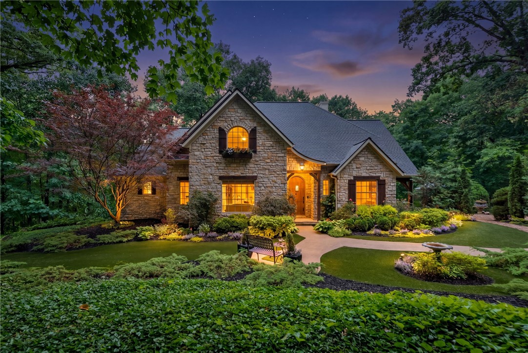Nestled in the peaceful forest of Eureka Springs, this one-of-a-kind custom home feels like a true storybook retreat. Thoughtfully designed and lovingly built, the property blends natural beauty, privacy, and timeless charm. A picturesque wishing well welcomes you home, leading into a stunning cobblestone courtyard with outdoor fire pit and enchanting entertainment spaces made for gathering under the stars. Expansive decks and a treehouse-style screened porch immerse you in the surrounding forest canopy, creating a peaceful connection to nature from every angle. The carriage house includes an unfinished apartment above, offering endless possibilities for guest quarters, studio space, or future expansion. Rarely does a property capture this level of warmth, character, and tranquility while remaining just minutes from the charm, dining, and recreation of Eureka Springs & Holiday Island.