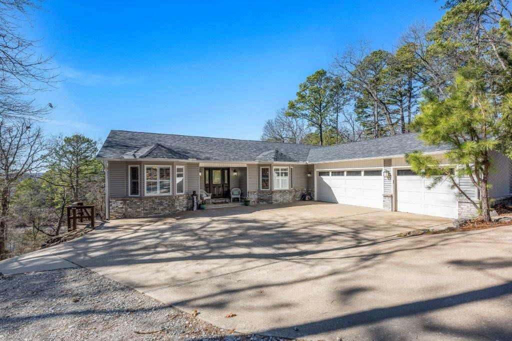 LAKEFRONT living w/PRIVATE BOAT DOCK on quiet & serene Lake Norwood, complete w/paved path to the water, in BENTONVILLE School District. Fabulous lakeviews thru the expansive double pane windows allow ample natural light. Primary suite & guest bedroom (main level) have private decks overlooking lake. The kitchen located in heart of the home, is a chef's dream featuring gorgeous granite w/large island, built-in buffet, & eat-in kitchen. 4 bedrooms+office, w/a Murphy bed for flexibility. Fully finished walk-out basement has abundant storage, 2nd full living quarters w/beautiful built-ins, wet bar, kitchen, 2nd living room, bonus room, laundry area & separate lower-level golf cart garage. LOTS of updates including a 50yr impact roof, freshly painted interior, & more! Easy access to Hwy 71, 7 golf courses, 5 lakes, gun range, mountain bike trails, restaurants & shopping +15 minutes to downtown Bentonville& new Walmart HQ. Lots 9&10 are not included but are negotiable. Perfect for an Airbnb or Come live the lake life!