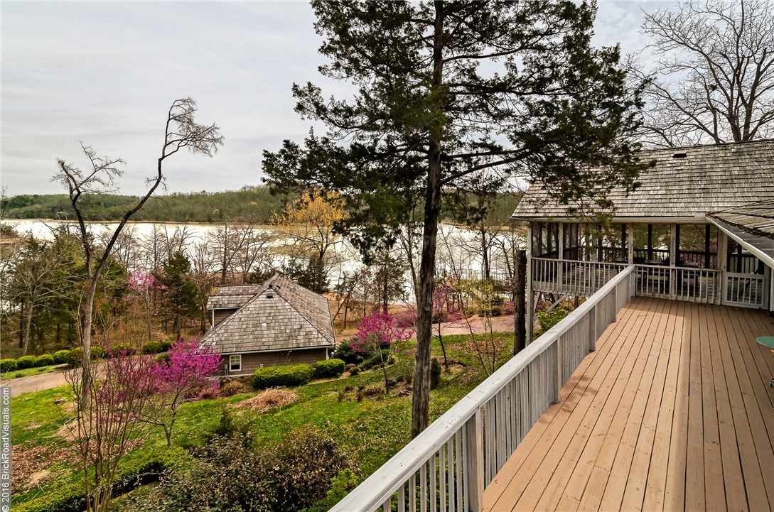 Lake Front Retreat! this amazing home looks over Beaver Lake with its own private two boat slip with one lift and double jet ski boat dock, level walk to the water and boat dock. This retreat living also includes a guest house and an extra .55 acre lot for,building additional guest homes or garages. This home is gated & on all paved public roads and a short drive into Rogers, fully furnished and ready to move in just bring your boat and jet ski's. Home would make a great investment for business retreats!