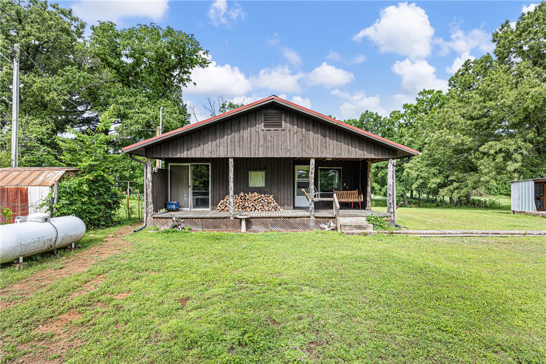 Charming cabin-style home situated on 1.54 acres just minutes from Mount Nebo State Park. This 2-bedroom, 1-bath property offers a unique blend of rustic character and modern functionality, making it ideal as a primary residence, weekend retreat, or potential short-term rental.
Interior features include cedar walls with custom wood accents of walnut, pecan, pine, and persimmon, creating a warm and inviting atmosphere. The living area includes a wood-burning stove, complemented by two mini-split systems providing efficient heating and cooling. Additional propane heaters offer supplemental heat. The kitchen is equipped with a propane stove, and the home features an electric water heater.
Spacious laundry room with updated plumbing. Exterior highlights include a covered back porch, a metal roof (approximately 7 years old with a 50-year warranty), a barn for storage or hobby use, and a carport for covered parking.