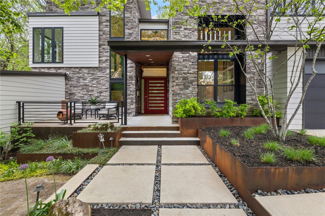 A rare modern residence set within the historic district that's thoughtful, precise, and quietly bold. This 2018 home offers 4 bedroom suites with 3 full and 2 half baths, plus a bonus room, dedicated office, full gym, and formal dining - arranged across a private 0.58-acre setting with wet-weather creek and fire pit. Expansive windows create a treehouse-like feel with natural light throughout. The kitchen features professional-grade appliances, waterfall quartz island, custom cabinetry, and a walk-in pantry with pass-through access to the oversized 3-car garage. The primary suite includes a private porch, spa-like bath, and oversized custom closets. Outdoor spaces include a gunite pool with water feature, spa, gas fire table, covered dining with built in heater, outdoor grill, and landscaped grounds with a seasonal creek. Custom dog runs with built-in access doors add a thoughtful, functional touch. You really must see this fully realized example of modern living in the beloved Fayetteville historic district.