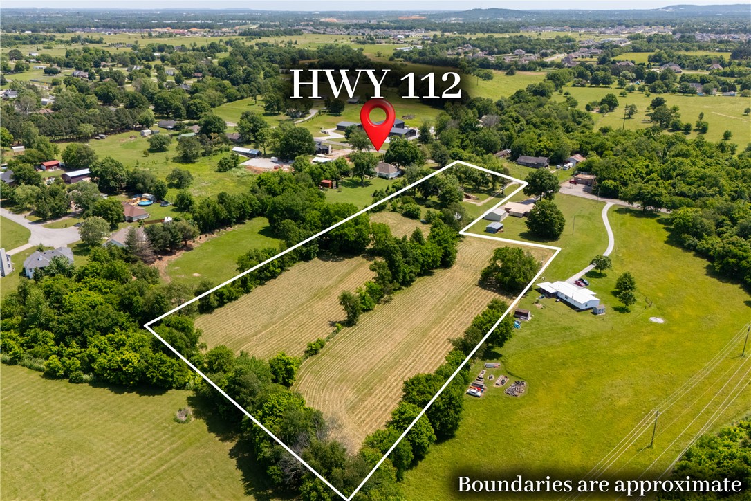Land this clean, this close to the highway, with a move-in ready home already in place is a hard to find gem. The sale combines a 3.31-acre homesite with a contiguous 2.31-acre lot, giving you frontage, flexibility, and a real foothold in one of Northwest Arkansas' fastest-growing corridors. Develop, subdivide, run animals, or simply own the buffer around you. No HOA telling you which.

Inside, hardwood floors, cathedral ceilings, and a wood-burning fireplace give the home real character. A dedicated library/study works as a home office or flex room, and walk-in closets in every bedroom keep things practical.

Out back, a screened porch overlooks open pasture and a 30x30 detached metal shop handles the equipment, the projects, or the toys.
Homes with this combination of a turn-key residence, working outbuilding, and development-grade acreage on a paved highway corridor rarely hit the market in Elm Springs. Worth a closer look.

*Less than 1 mile away from the HWY 612 extension that's opening in August 2026*