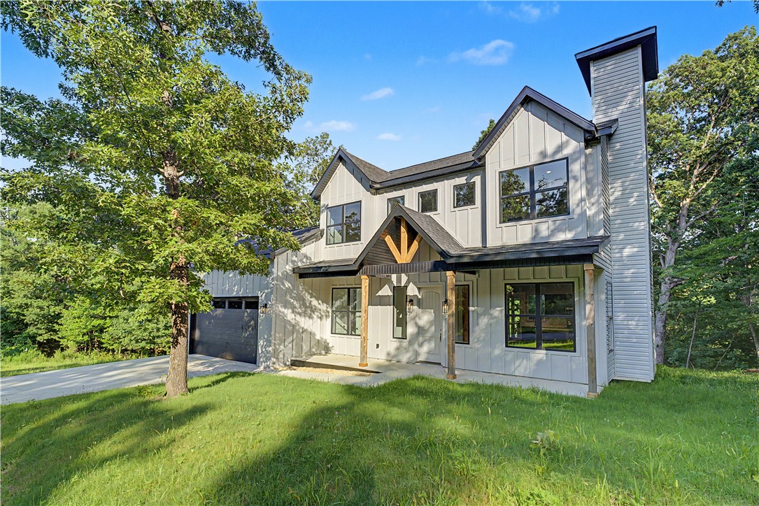 Nestled among the trees in Bella Vista, this beautiful new home offers modern farmhouse charm and a private wooded setting. The open-concept layout features a spacious living area with a fireplace, abundant natural light, and a seamless flow into the kitchen and dining spaces. Enjoy peaceful views of the natural ravine from the elevated back deck, creating the perfect place to relax and unwind. Additional highlights include a 2-car garage, stylish finishes throughout, and convenient access to Bella Vista's trails, lakes, golf courses, and other sought-after amenities.  *****SELLER PAID CLOSING COSTS CREDIT OF $4,000***** Property perc was for a 2 bedroom