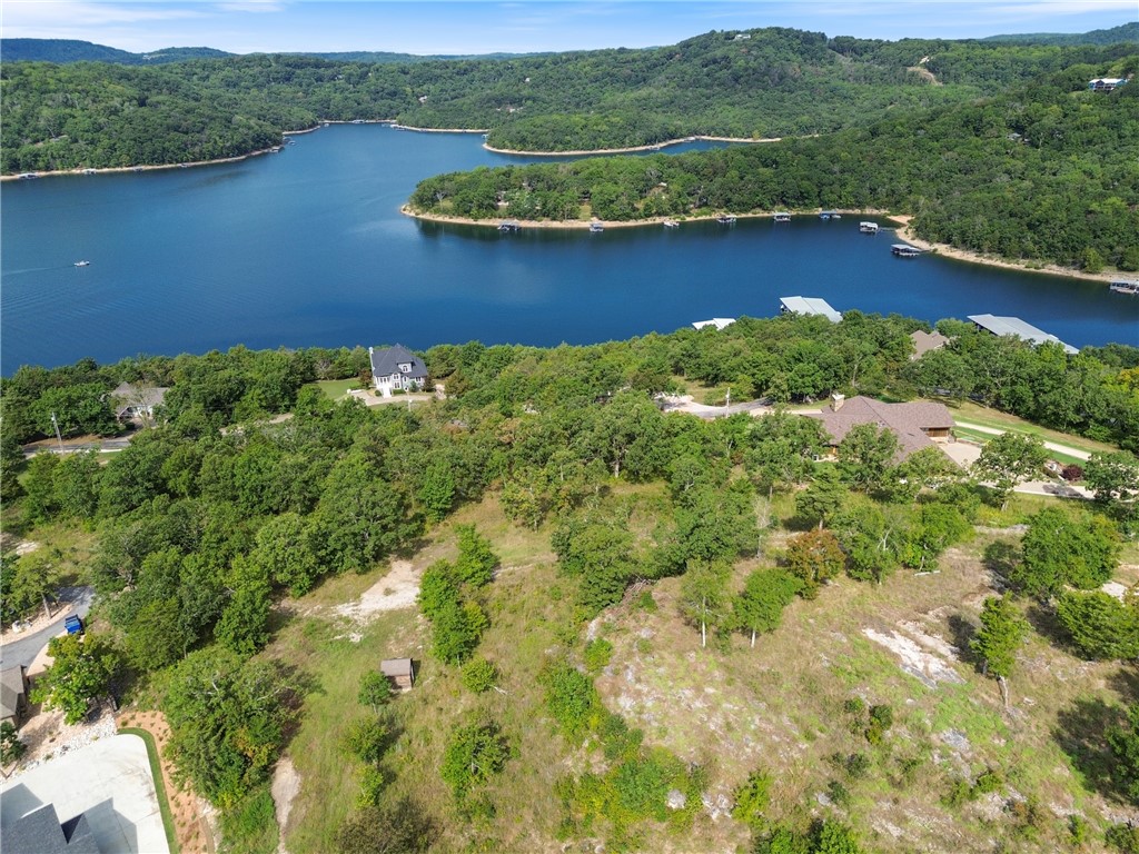 The perfect opportunity to own a stunning +/- 2.05 acre wooded lot in the highly sought-after gated community of Del Lago. Nestled in a private setting, this property offers breathtaking views of Beaver Lake and includes access to a boat dock and dedicated slip, making it an ideal location for building your dream home or a peaceful lake retreat. Utilities are conveniently available at the street, including electric, public water, and community sewer service exclusive to Del Lago. Residents enjoy the security and amenities of this well maintained subdivision with annual fees of $879 for the Del Lago POA, $135 for sewer, and $725 for the boat slip. Whether you are looking for a full time residence or a weekend getaway, this property combines natural beauty, modern conveniences, and direct lake access in one of Northwest Arkansas's most desirable communities.