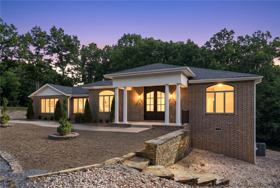 Like-new without the wait! This beautifully renovated Bella Vista Home is move-in ready & situated on a private 0.69-acre lot surrounded by natural beauty. Thoughtfully updated w/quality craftsmanship throughout, home features hardwood flooring, quartz countertops, stainless steel appliances, abundant storage, & warm, inviting living room centered about a modern electric fireplace. For added peace of mind, both the roof and HVAC system were replaced in 2025. The bright sunroom offers flexible living space for a home office, reading room, or additional entertaining area. Step outside to the oversized deck overlooking a peaceful, wooded setting-perfect for relaxing or hosting family & friends. The oversized three-car garage provided exceptional space for vehicles, hobbies, or a workshop. Ideally located just minutes from Lake Avalon, the new Bella Vista Bike Life, & Northwest Arkansas' world-class trail system, this home offers exceptional access to outdoor recreation while remaining convenient to everyday amenities.