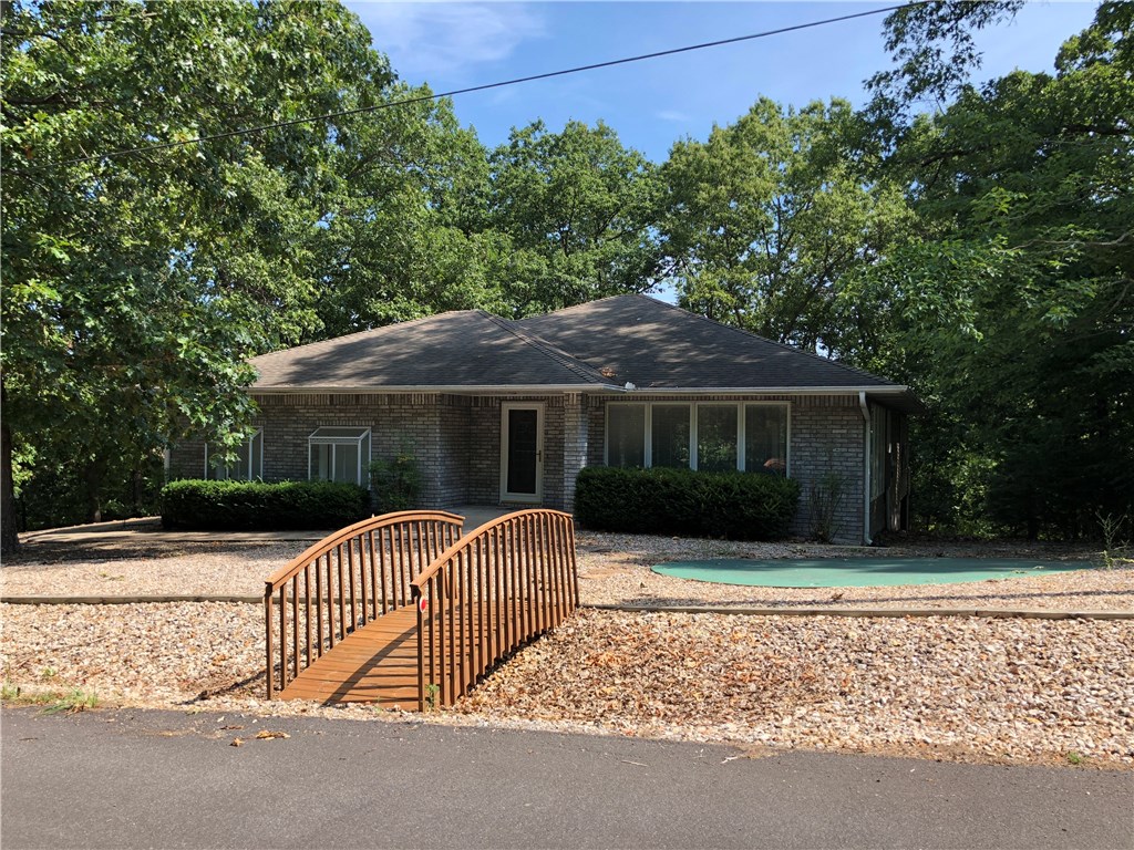 Enjoy Bella Vista living at its finest in this immaculate home in Harlow subdivision. This home is light and bright and in a quiet, secluded wooded area.  Walk down the block to London Landing Boat launch and picnic area.  Practice your putting skills on your own personal  putting green.  Relax on the huge deck over looking wooded area or in the enclosed sunroom.  There is plenty of space in the oversized 2 car garage to park a golf cart. The kitchen is a chef delight with lots of storage space.  Crawl space offers great storage as well.