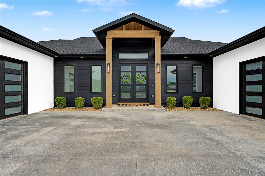 Stunning single-story modern home on a flat 1.2-acre lot in a gated Centerton community, just minutes from I-49. This 3,538 sq ft, 4 bed, 3.5 bath home blends clean design with everyday comfort & functionality. Open floor plan features a chef’s kitchen with oversized island, gas range, walk-in pantry with appliance station, & seamless flow into the main living space. Spacious primary suite offers serene backyard views, complemented by a large, dedicated office and additional flex space ideal for a gym, second office, nursery, or more. Smart home automation controls garage doors, locks, lighting, HVAC, security, blinds, & more, supported by Cat6 wiring. Enjoy outdoor living with a covered patio, electric blinds, outdoor kitchen, and new Pergolux pergola. Two oversized 2-car garages with epoxy floors, EV charger, and dog wash station add convenience. Beautiful white oak cabinetry throughout home. Bentonville School District. Close proximity to Bentonville West High School & Centerton Gamble Elementary. (agent owned)