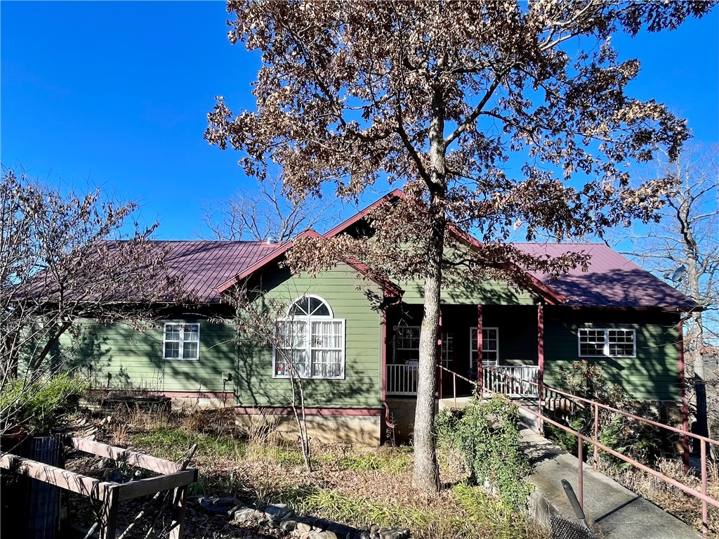 11.5 acres in the beautiful Ozarks! This custom home, built in 2006, situated on secluded wooded acres with a natural spring flows year round, offering views for miles from its back deck. The main floor comprises 3bed/2.5baths including one room currently used as an office with a half bath. A guest bedroom features its own private bath, while the primary bedroom boasts a jacuzzi bath, separate walk-in shower, and double vanity. A 492 sq ft basement includes 1bath & office/flex room.13x16 storm shelter used as bedroom.Steel fire door. A new generator providing emergency backup power. The property also features a 610 ft well with a new pump and tiles, a new double oven in the kitchen, a separate water heater for the kitchen, complemented by an 80-gallon water heater for the rest of the home. A 12x12 storage building and Ozarks Go Fiber Optic internet and cable services available. Approx 35-40 min commute to Fayetteville & Springdale, AR.