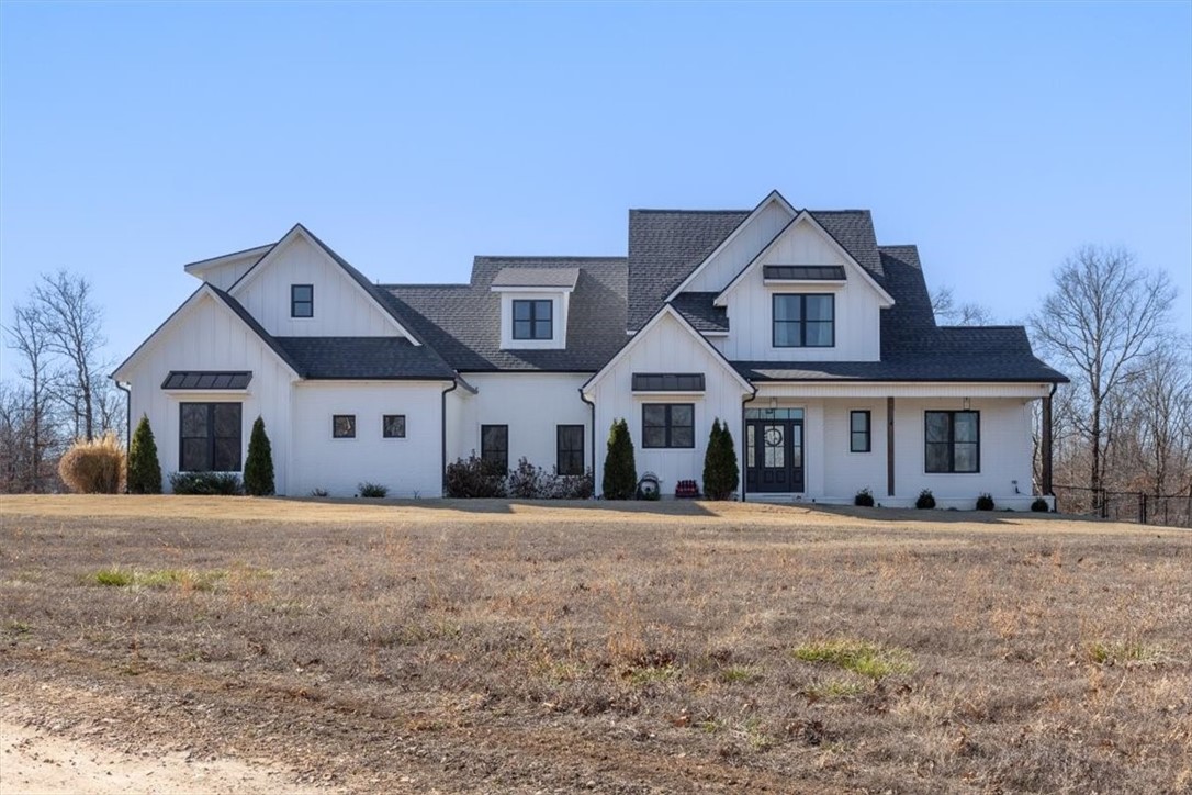 Tucked away on 8.24 private acres, this like-new Craftsman-style home blends timeless charm with modern luxury! Enjoy a 3-car side-entry garage, exterior lighting, professional landscaping, and a welcoming covered front porch. The backyard is an entertainer’s dream with a private in-ground pool and spacious patio already prepped for a hot tub. Inside, the open floor plan features vaulted ceilings, wood floors, and picture windows that flood the home with natural light. The chef’s kitchen boasts stainless appliances, a gas cooktop with pot filler, large eat-in island with storage, spacious pantry, under-cabinet lighting, and flush-mounted cabinetry. Relax in the stunning primary suite with trey ceiling, private patio access, and spa-like bath. The main level also includes a large laundry room with sink and cabinetry plus a flex room ideal for an office or gym. Upstairs offers a guest suite with private bath and two additional bedrooms with a full bath on the opposite wing
