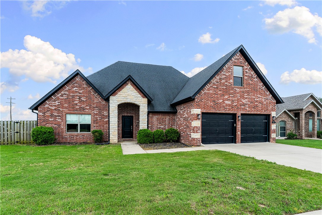 Located in the desirable Sunrise Ridge subdivision, this north-facing all brick and stone home offers 3 bedrooms, 2.5 bathrooms, and a versatile bonus room that could serve as a 4th bedroom, media room, playroom, or home office. Situated on a spacious 0.32-acre corner lot, the fully fenced backyard provides plenty of room for outdoor enjoyment and even future pool potential. The open-concept floor plan features abundant natural light, wood-look tile flooring throughout the main living areas, and a modern gas fireplace in the living room. The kitchen is equipped with granite countertops, stainless steel appliances, a gas range, pantry, and designer lighting. The primary suite includes a fully tiled walk-in shower, jetted tub, double vanity, enclosed toilet area, and large walk-in closet. Upstairs bonus room includes a half bath for added flexibility. Enjoy relaxing on the covered back patio while being conveniently located near Centerton Gamble Elementary, Bentonville West High School, and Kinyon Sports Complex.