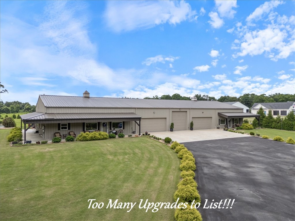 This exceptional Barndominium is built with commercial red iron framing rather than traditional pole barn or wood barn construction, offering outstanding durability and long-term quality. The property includes two separate living spaces: a 2,350 sq. ft. primary residence and a 1,406 sq. ft. ADU, making it ideal for multigenerational living, guests, or rental income. The home features 3 cm granite on the kitchen and bathroom countertops and windowsills, with cultured marble on all shower surfaces.  A tree-lined front road creates privacy and a peaceful setting while still being conveniently close to town, shopping, and daily amenities. With no POA restrictions, owners enjoy added flexibility. The oversized garage accommodates multiple cars and trucks, and the center bay is designed for RV parking with an in-floor sewer connection, 30-amp electric service, and water access. For added security, the siding and structure are rated for winds up to 120 mph, and an in-ground storm shelter is located in the garage area.
