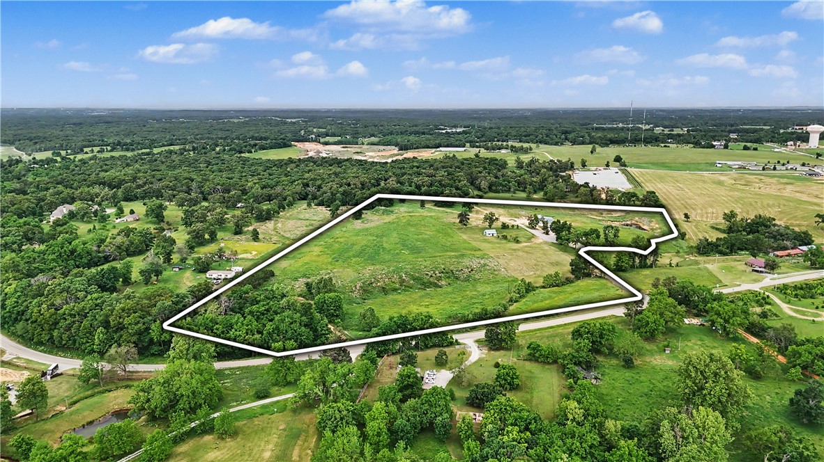 Prime 25+ Acre Development Tract with Highway 102 Frontage right outside of the growing town of Centerton. Capitalize on Northwest Arkansas' massive housing demand with this exceptional 25.04 acre development site. Position your next project directly in the path of progress. Featuring mostly flat, easily clearable acreage with minor rolling topography and small creek at the front of the property. This tract sits just 2 miles from Centerton's newest planned development. 
Multiple existing structures are currently present on the property. The modular home and storm shelter will be removed within 30 days of closing by the seller.
