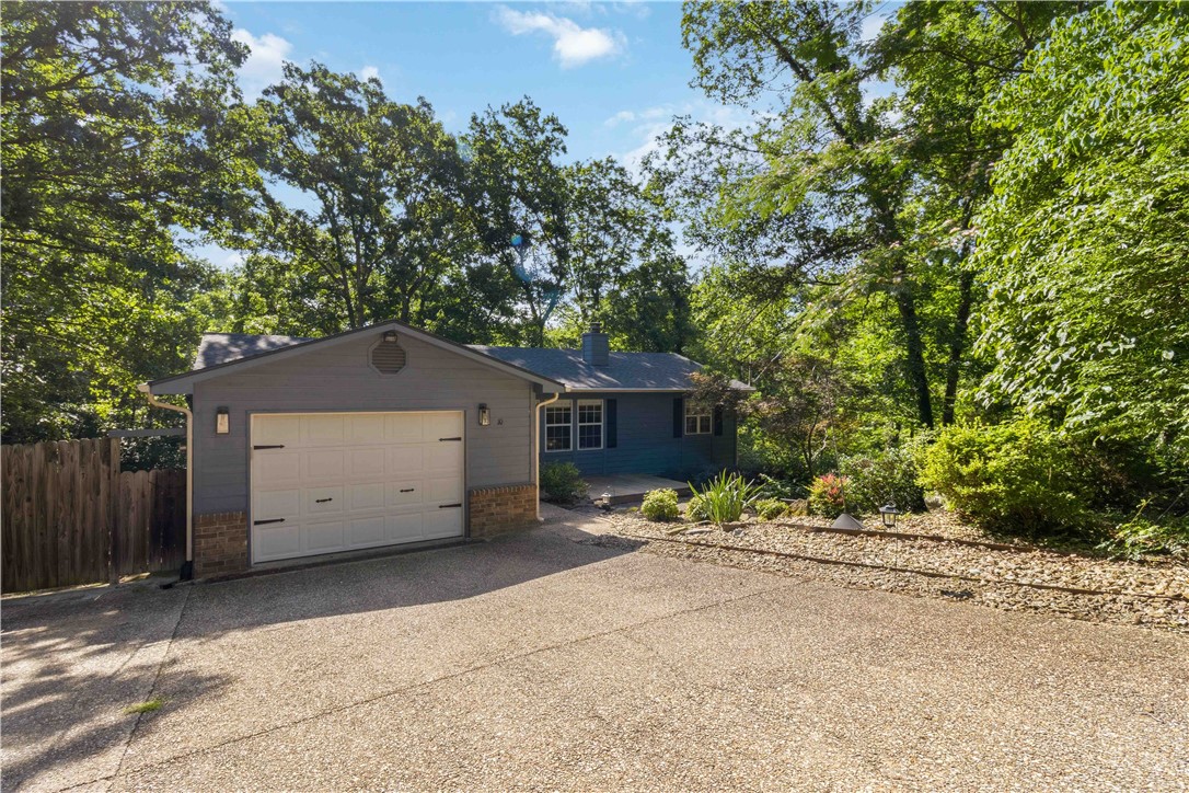 Nestled among the trees and backing directly to the Lago Vista Spur Trail, this updated Bella Vista home offers privacy and outdoor access just minutes from Lake Avalon. The spacious floor plan features a large living room with a brick fireplace, updated kitchen with stainless steel appliances and subway tile backsplash, built-in dining storage, a bonus room, and remodeled bathrooms. The primary suite includes a walk-in tiled shower and a large walk-in closet. Enjoy the expansive deck overlooking the wooded backyard. The insulated workshop/storage building features air conditioning and a wood-burning stove, making it ideal for hobbies, a workshop, or additional storage. Conveniently located near lakes, trails, golf, and all of Bella Vista's amenities.
Roof, guttering, gutter guards, & water heater replaced in 2023.
