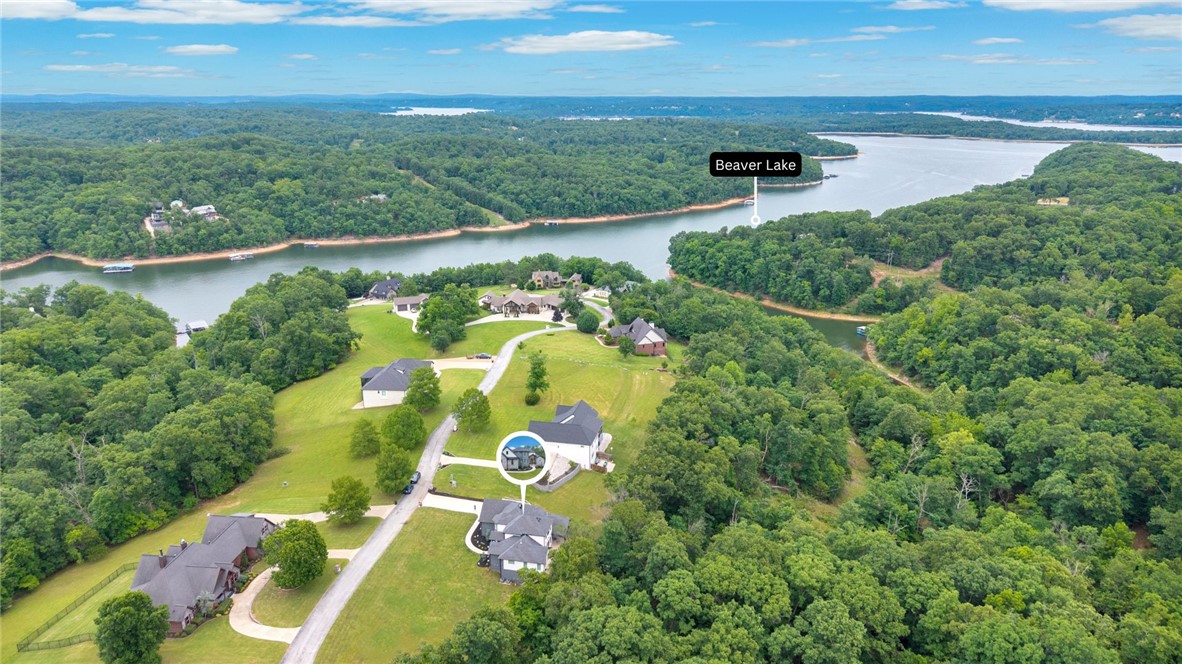 Luxury, Privacy, and Timeless Craftsmanship! Stunning 2023 custom estate on 2 private wooded acres in the gated Estates of Lakeway. Designed for effortless entertainment and everyday comfort, the open floor plan flows beautifully, creating an inviting atmosphere filled with natural light and upscale finishes. The luxurious primary suite serves as a private sanctuary, complete with a cozy fireplace, sitting area, and direct access to the expansive patio. A fully finished walkout lower level offers flexibility with a spacious living area, game room featuring a custom wet bar and kitchenette, media room with theater-grade surround sound wiring, ideal for guests, multigenerational living, or a teen retreat. Surrounded by mature trees, the outdoor living spaces provide the perfect setting to relax, entertain, and enjoy peaceful evenings. Access to three community docks makes it easy to enjoy swimming, kayaking, fishing, and the Beaver Lake lifestyle.