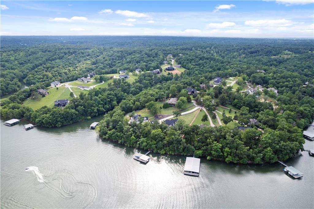 Luxury, Privacy, and Timeless Craftsmanship! Stunning 2023 custom estate on 2 private wooded acres in the gated Estates of Lakeway. Designed for effortless entertainment and everyday comfort, the open floor plan flows beautifully, creating an inviting atmosphere filled with natural light and upscale finishes. The luxurious primary suite serves as a private sanctuary, complete with a cozy fireplace, sitting area, and direct access to the expansive patio. A fully finished walkout lower level offers flexibility with a spacious living area, game room featuring a custom wet bar and kitchenette, media room with theater-grade surround sound wiring, ideal for guests, multigenerational living, or a teen retreat. Surrounded by mature trees, the outdoor living spaces provide the perfect setting to relax, entertain, and enjoy peaceful evenings. Access to three community docks makes it easy to enjoy swimming, kayaking, fishing, and the Beaver Lake lifestyle. $4,000 Lender Credit Available.