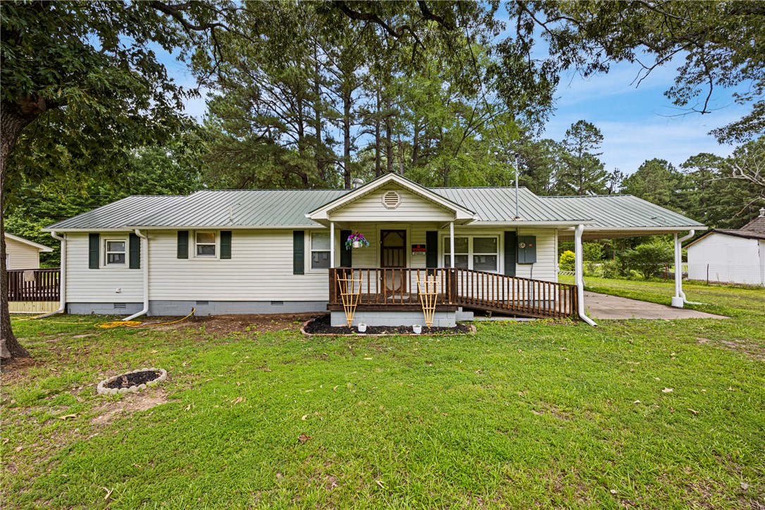 Newly remodeled and updated home on a large shaded lot in town. Two large bedrooms with a smaller room that could be used as a office or craft room. Newly added half bath, refurbished oak floors, metal roof, vinyl siding. A great additional feature is a small cottage with a living room, kitchen, bedroom and bath. Two large storage buildings. This is a must see property for the value with good access to major traffic patterns.