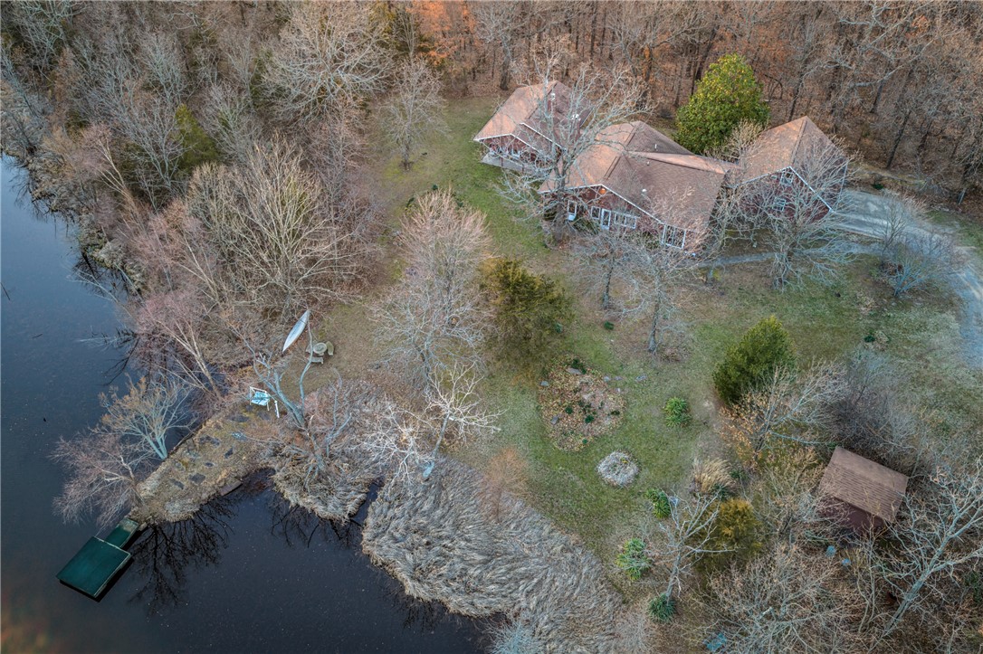 This Charming 3 BR 2 Ba ranch-type home was custom built and nestled on this 24 acres on Tony Mountain just South of Fayetteville.  The Home boasts an open Living area with wood burning fireplace, vaulted ceiling, and built-ins, Bright and cheery kitchen with granite countertops and a great view of the lake. The Sunsets from the back side of the home are spectacular as well! Split Bedroom plan. The Primary Suite is spacious with view of the Lake and a see-thru fireplace into the primary bath with jetted tub. There is a central Vacuum, Granite Countertops, tile floors, Berber carpets. Roof is approximately 7 years old. Screened covered porch overlooking the private lake.  Large 2 car garage with closets and above the garage is a finished studio room with wall a/c.  Welcome Home!