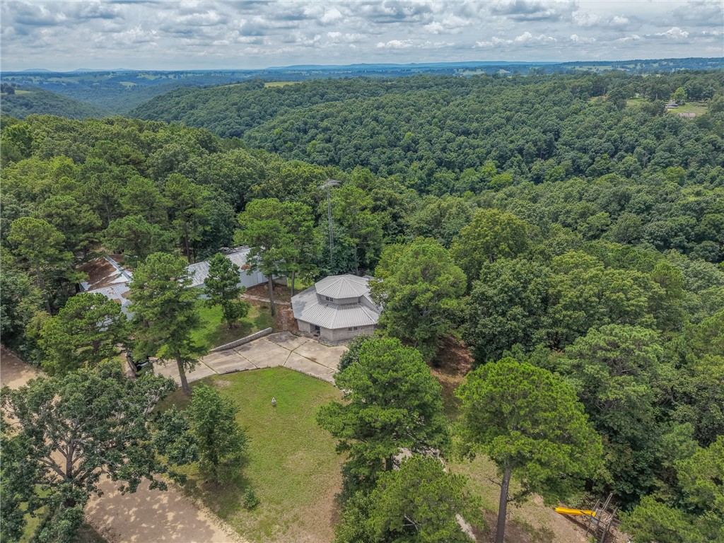 This isn't a house. It's a stronghold. Planted on 7 unrestricted acres in the Ozark hills and wrapped in 16" of solid poured concrete, this fortified homestead was built to stand when everything else falls. The 2,309 sqft main home doesn't just survive—it lives well: 3 bedrooms, 2 baths, a den, and a bonus room, all dialed in with new HVAC, new well pump, new wiring & fuse box, and fully inspected electrical. Step outside to a 3,000 sqft steel shop anchored on an 18" concrete slab that doubles as the roof of a reinforced underground bunker—big enough for multiple families and wired with its own power, plumbing, and diesel backup. A hidden tunnel once ran straight from the bunker into the house. Above the shop, an unfinished apartment stands ready for guests, in-laws, or rental income, while twin buried semi-truck tanks keep gravity-fed water flowing after the grid goes dark. Total independence—no HOA, no compromise, no equal. Untouchable. Unrepeatable. Unlike anything in Boone County. Come claim the fortress.