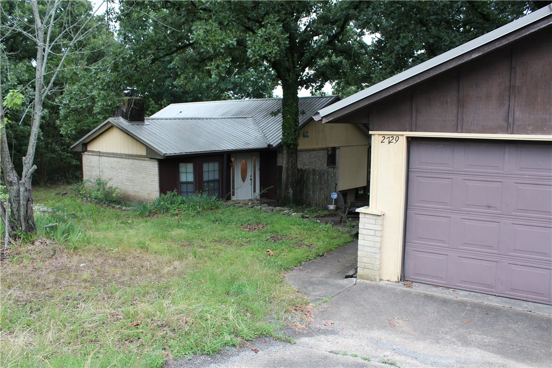 Located approximately 3 miles north of Clarksville on CR 3348, this 2,700-square-foot residence sits on 6.4 scenic acres. The home features 3 bedrooms and 2.5 bathrooms, anchored by a spacious kitchen and dining area and a large living room with a fireplace. Vaulted ceilings enhance the interior's sense of space. The fully finished walkout basement includes one bedroom with a full bath and the laundry room, while the central basement area provides a versatile space suitable for a den or game room..
Constructed with a durable metal roof, brick, and wood siding, the home's exterior is designed for longevity. A spacious deck provides a perfect venue for entertaining while overlooking the property's expansive landscape of mature hardwoods. Additionally, the grounds feature a detached two-car garage, a carport, and a 24'x24' shop, all of which are accessible via a paved driveway.