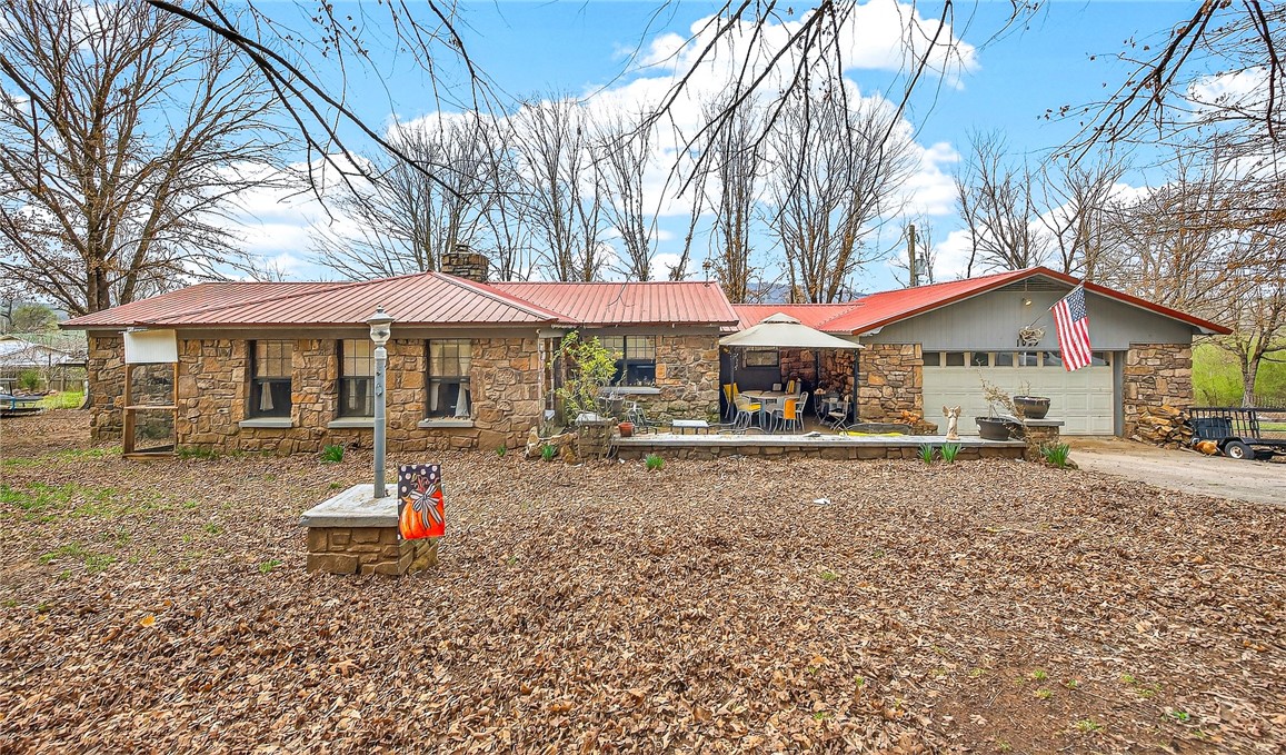 Experience the best of country living in Mountainburg! This comfortable 3-bedroom, 2-bath home on just under an acre boasts a native stone exterior topped with a sleek, metal roof. Kick back and relax in the spacious living area and functional, eat-in kitchen with storage galore. This rural charmer also features a large 30x60 (Approx.) shop, complete with its own electric meter and woodburning stove. Tucked away in the heart of the Boston Mountains, Mountainburg is roughly 30 minutes from Fayetteville, 30 minutes from Ft. Smith, 10 minutes from Alma and 10 minutes from Lake Ft. Smith. What better place to enjoy quiet, peaceful country living than in the very heart of the Ozarks!