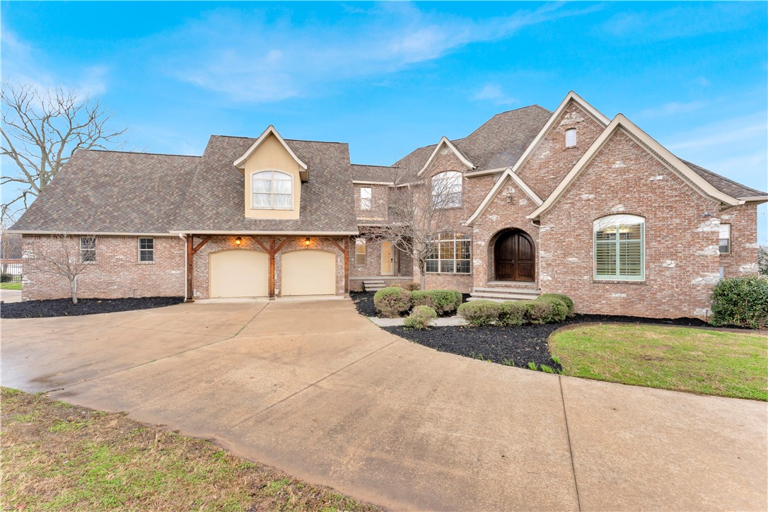 Experience elevated lake living in this fully refinished luxury estate with year-round Beaver Lake views and private community boat dock and slip with lift access in a gated community. Offering over 7,500 sq ft, this exceptional home features a private pool, multiple outdoor living spaces, and breathtaking natural surroundings. Thoughtfully updated with new hardwood floors, designer paint, new carpet, new roof, new HVAC unit, and a beautifully renovated chef's kitchen with custom cabinetry and premium finishes. Walls of windows showcase stunning lake views while filling the home with natural light. Multiple fireplaces, expansive living areas, a game room, fitness room, and flexible bonus spaces create the perfect setting for entertaining or everyday living. Enjoy the rare combination of luxury, privacy, and lake lifestyle just minutes from Rogers and Bentonville.