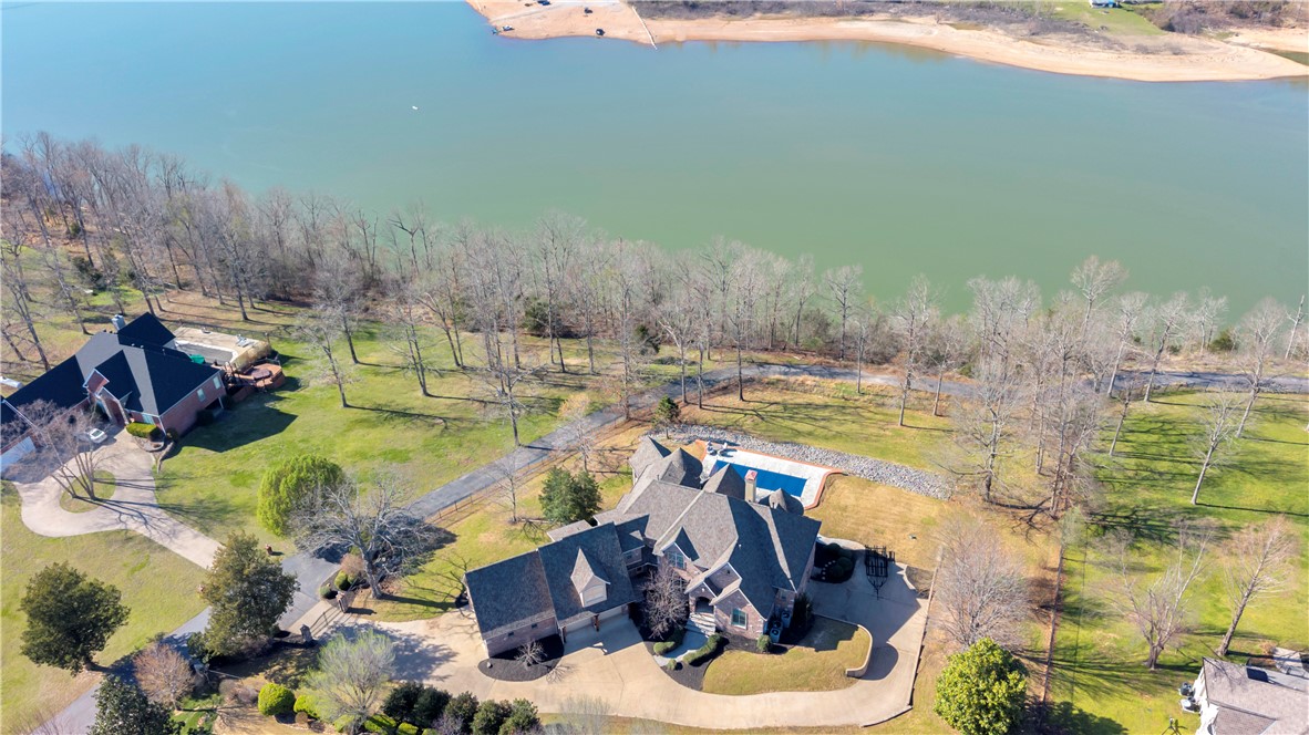 Live where every weekend feels like a getaway. Set behind the gates of Falcon Crest, this exceptional Beaver Lake estate offers year-round lake views, private community boat slip and dock access, and over 7,500 sq ft designed for gathering, entertaining, and making lasting memories. Spend mornings on the water, afternoons by the private pool, and evenings enjoying breathtaking sunsets from multiple outdoor living spaces. Inside, you'll find a beautifully reimagined chef's kitchen, new hardwood flooring, designer paint, new carpet, new roof, new HVAC, multiple fireplaces, expansive living areas, a game room, fitness room, and flexible spaces for guests or multi-generational living. Just minutes from Rogers and Bentonville, this rare luxury retreat delivers the privacy of a gated community with the convenience of city amenities and the lifestyle only Beaver Lake can offer.