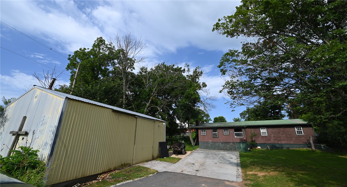 High visibility home and work shop on Highway 7 South!  Located just south of Harrison, this property offers highway frontage and a highly accessible location. The home features 3 bedrooms, 1 bathroom, and approximately 1,720 square feet of interior space. Exterior includes wood siding, metal roof, and an enclosed front porch. Outside, the 0.3-acre lot features established garden area and detached metal garage/outbuilding - - perfect for storage, a workshop, or hobby space. Property being sold in "as is" condition.