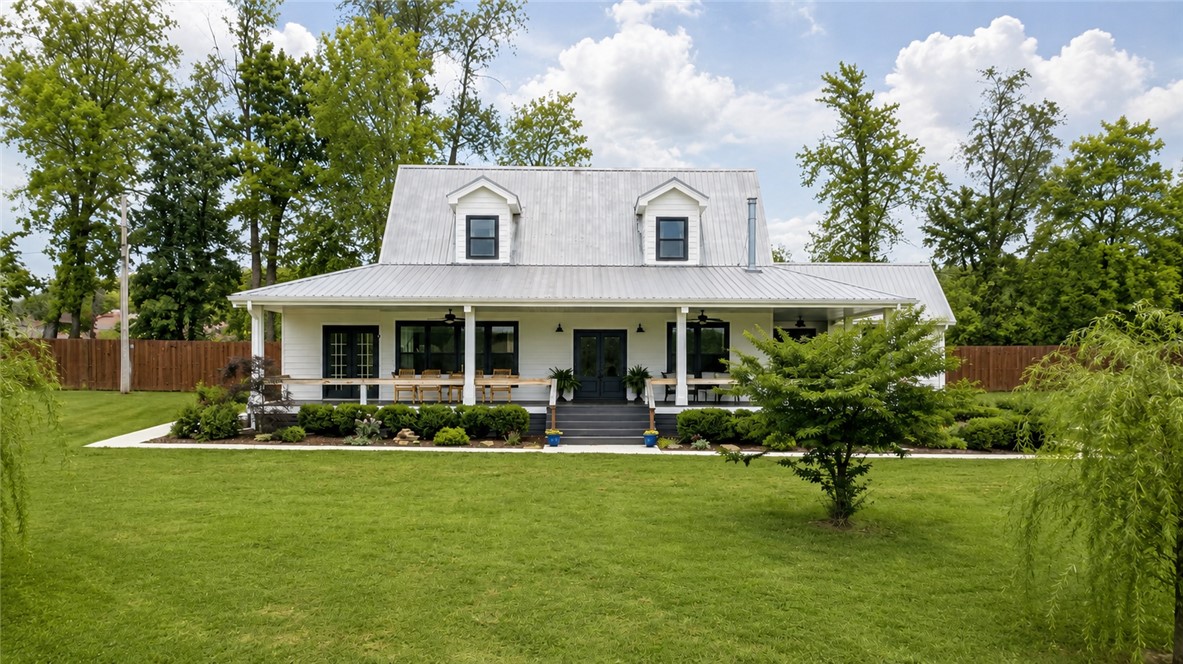 Beautifully-renovated Farmhouse on 7.5 Acres, only 15 Minutes from downtown Fayetteville!  The property features breathtaking sunset views, a peaceful pond, and lush fields that gently roll up to the house & pond.  Guest Apartment above the extra-spacious detached garage.  Brand new 8-foot privacy fence just added!  Upgrades in 2023 include a stunning kitchen with quartz countertops, an over-sized shower in primary bath, and new windows, flooring & paint.  Both the house and the grounds have been so well maintained, and the 50'x42' barn is ready to go with water & electric.  Relax on the classic wraparound front porch, or by the Mimosa trees at the pond.  The office in the primary bedroom can double as a walk-in closet.  This combination of extra acreage and proximity to Fayetteville is a rare find.  The metal roof and high-quality siding make this home even more appealing for long-term upkeep.  Don't miss this opportunity for a taste of country living that's not too far removed, schedule a showing now!