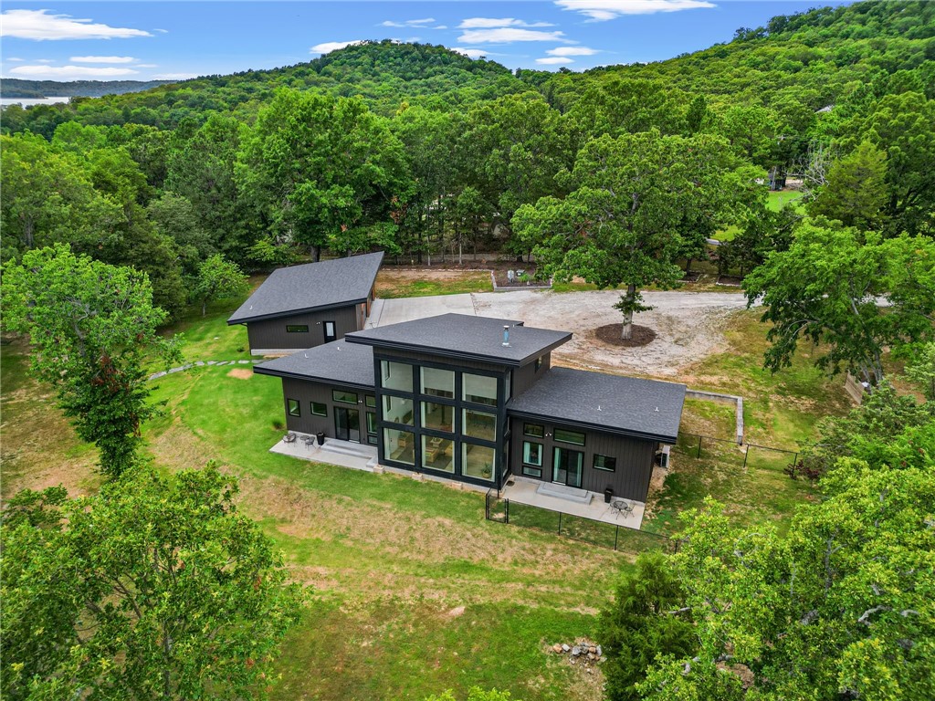 What a find! This Beaver Lake lakefront home has year-round water views, a private boat dock, and over 7 mostly flat acres! Built in 2020, this contemporary home boasts neutral, modern finishes throughout. Large windows invite the outdoors in and create a bright, open, airy atmosphere! Two, main level primary suites flank the centrally located kitchen & great room areas. Another bedroom/office has an oversized closet for extra storage. Upstairs is a full bath and multi-purpose loft that could easily be partitioned off for an additional bedroom suite. The oversized garage has tall ceilings and even a half bath for convenience! There are a variety of outbuildings for storage along with a greenhouse and an enclosed, raised bed area for the gardening enthusiast! The flagstone patio/firepit is a perfect spot to relax and unwind while gazing out over the lake. This rare, flat parcel lends itself to so many uses and provides for a very gentle walk to the single-slip boat dock w/swim deck. Check out the virtual tour video!