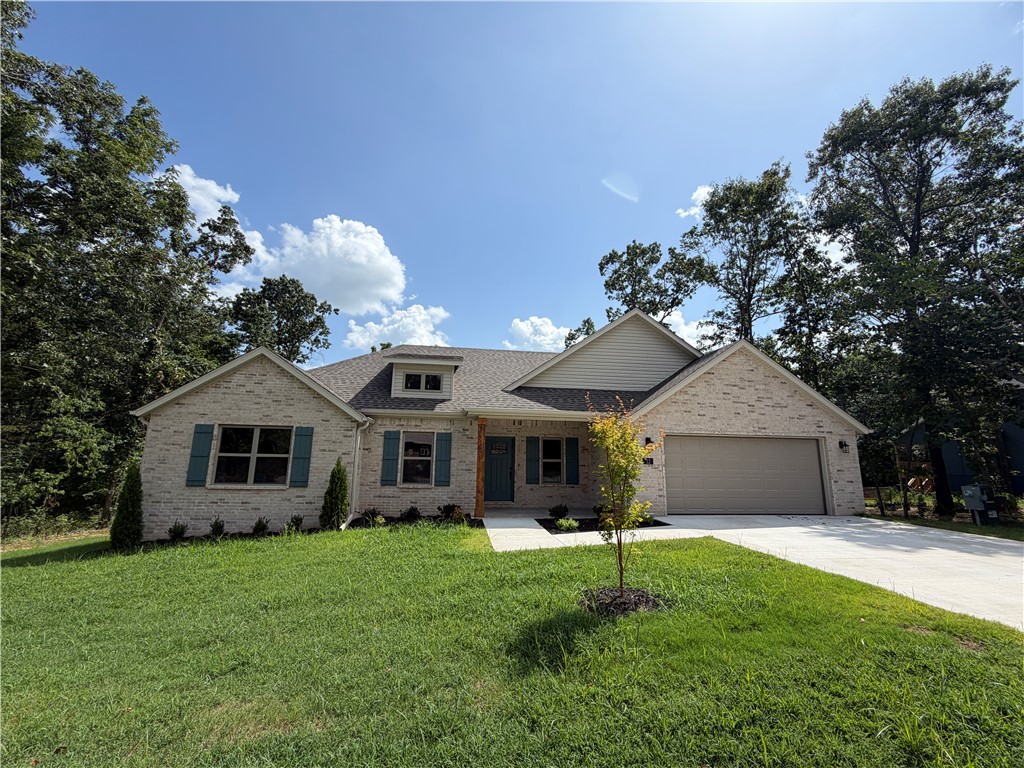 Enjoy Bella Vista living in this stunning new construction home near Lake Loch Lomond! This thoughtfully designed 3-bedroom, 2-bath home offers easy access to Bella Vista's incredible amenities. Inside, you'll find custom cabinetry, a cozy gas fireplace, a functional mudroom with built-in bench, and a spacious laundry room with ample cabinetry and counter space. The private primary suite features dual closets, a jacuzzi tub, and a separate shower. Step outside to a covered back patio overlooking a large, level, tree-lined backyard—perfect for relaxing or entertaining. Additional highlights include energy-efficient propane heat for enhanced warmth and backup heat during winter power outages, a propane tankless water heater, and the home is pre-plumbed for a propane range. This exceptional home combines quality craftsmanship, thoughtful design, and modern efficiency with the Bella Vista lifestyle. *Please note gas logs are not provided for liability reasons. Septic system is rated for 2 bedrooms.