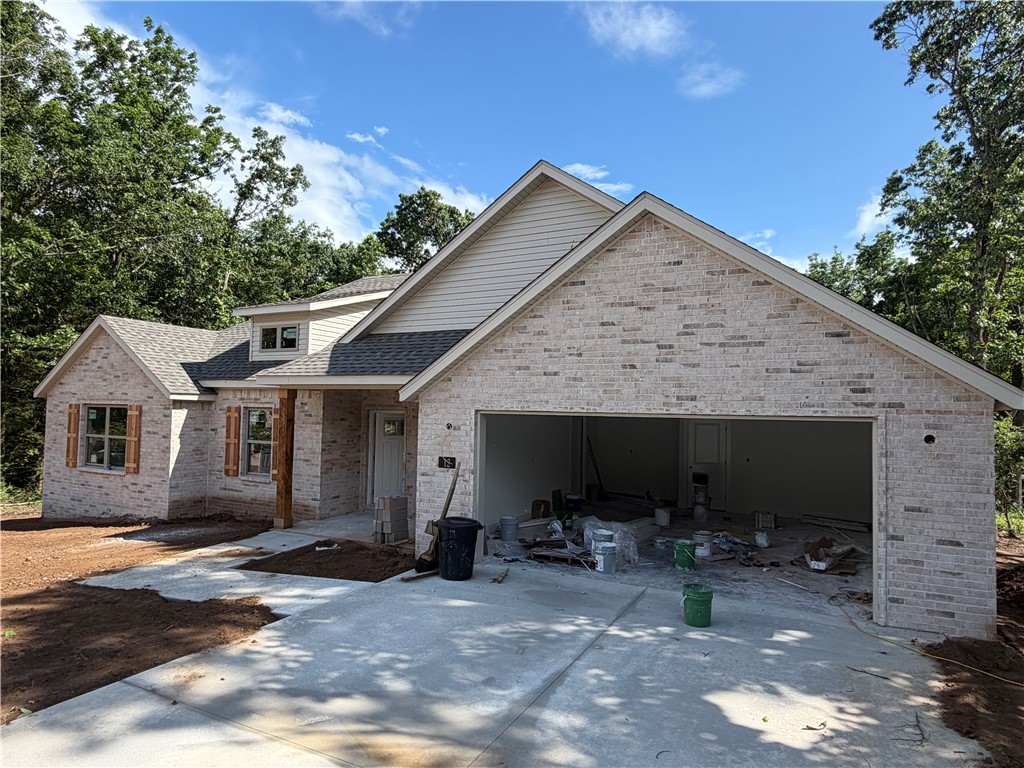Enjoy Bella Vista living in this stunning new construction home near Lake Loch Lomond! This thoughtfully designed 2-bedroom, 2-bath home with a versatile hobby room offers easy access to Bella Vista's incredible amenities. Inside, you'll find custom cabinetry, a cozy gas fireplace, a functional mudroom with built-in bench, and a spacious laundry room with ample cabinetry and counter space. The private primary suite features dual closets, a jacuzzi tub, and a separate shower. Step outside to a covered back patio overlooking a large, level, tree-lined backyard—perfect for relaxing or entertaining. Additional highlights include energy-efficient propane heat for enhanced warmth and backup heat during winter power outages, a propane tankless water heater, and the home is pre-plumbed for a propane range. This exceptional home combines quality craftsmanship, thoughtful design, and modern efficiency with the Bella Vista lifestyle. *Please note gas logs are not provided for liability reasons.