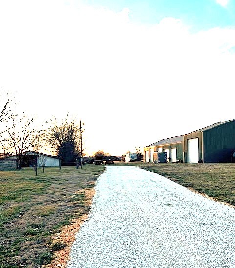 10 acres mol of level land is perfect for developing or as your in town estate. Sewer and all utilities available. Existing home on city sewer. Home is livable as is but could use TLC. 38 x 300 poultry house for storage and a very nice 40 x 90 shop building with 6 overhead doors.
