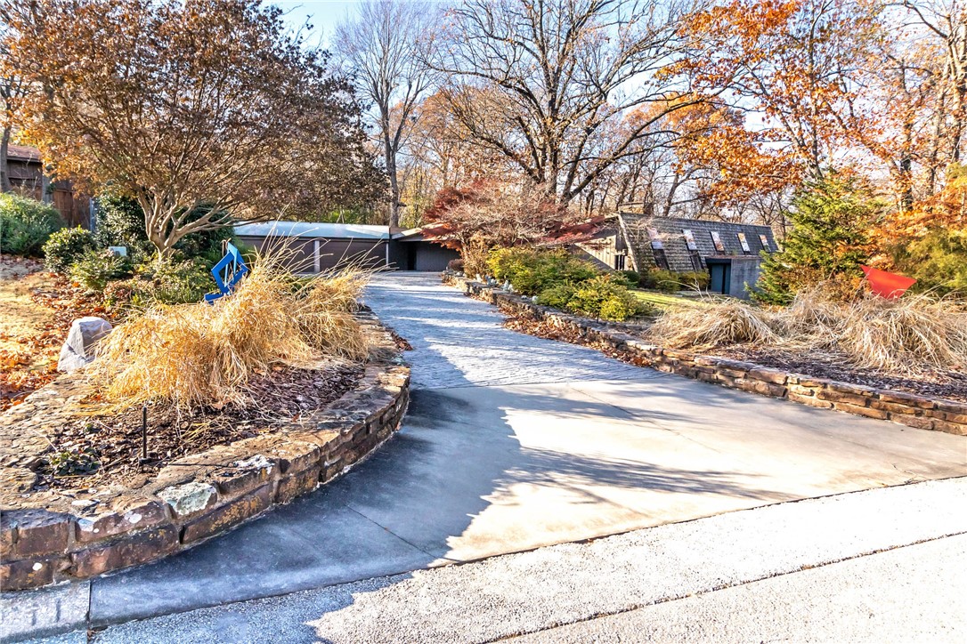 Enchant your senses at this inviting contemporary home on Mt. Sequoyah! Pass lavish landscaping as you enter your modern patterned concrete driveway into a 4 car garage with a Tesla car charger. In the heart of Fayetteville, full of trees, stone patios, rock walls, stone walkways, lush gardens + inspirational designer sculptures on .88 acres! Inside enjoy 3 LRs, 2 stone fireplaces, + huge master suite with a spa-like bathroom. Tons of storage, built-ins, + natural light! Marble, wood, + stone accents provide timeless appeal. Other noteworthy features include a $1.9M expansion designed by Marlon Blackwell, 1,000 sf fully equipped gym, 80K whole house generator, 800 bottle wine cellar with climate control, + numerous skylights! Come tour this estate today!! Property to be sold "As-is."