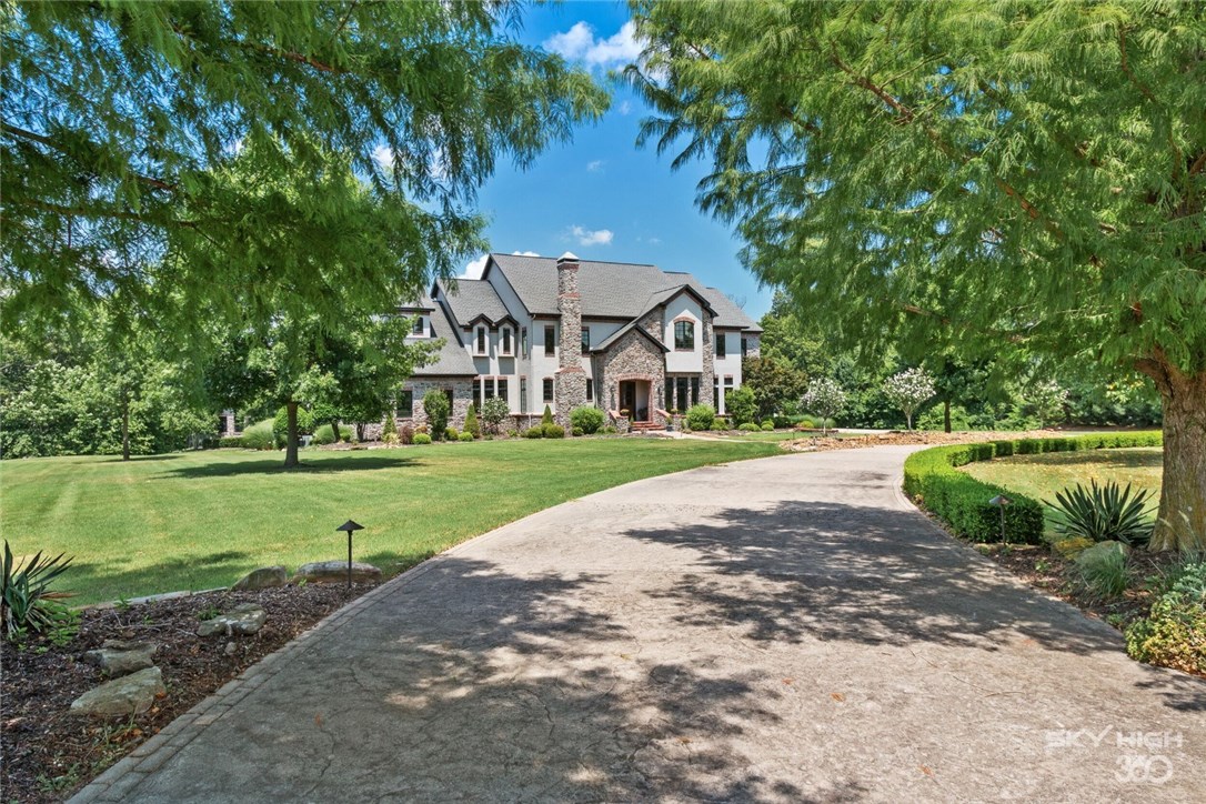 Private backyard oasis w/multi-level patios, pool decking, heated pool, 2 kitchens, shower, separate fire pit, covered patio w/FP & 730 SF guest house. Professionally mature landscaping. Open floorplan, great for entertaining. Master BR downstairs/4 BRs upstairs. This dream home has Viking refrigerator, gas stove, 2 pantries, custom wine cellar, home theater, tons of built-ins, custom closet features, quality finishes & craftsmanship throughout. Minutes from the new Bentonville West HS & WM home office.