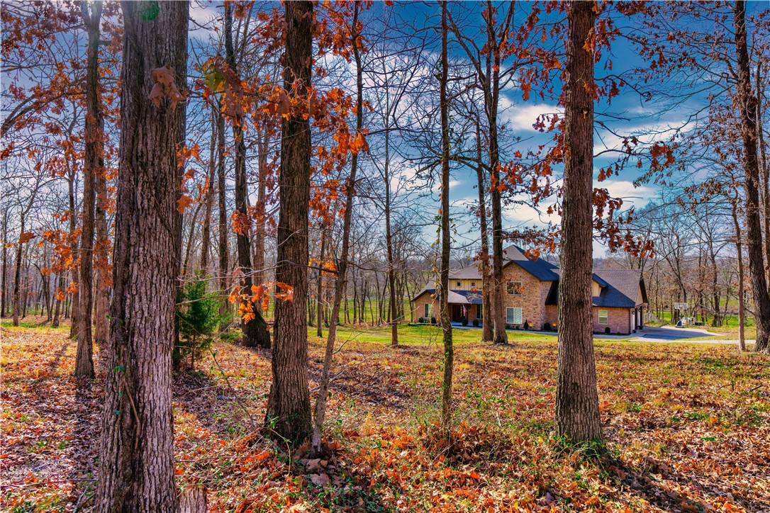 Beautiful custom built home on 9 acres with inground heated diving pool, hot tub, firepit, and covered porch. The land features treed area in the front and flatter area in the back that would be great for horses. Living room features high ceilings, fireplace, remote powered blinds and open to the kitchen and dining room. Kitchen has commercial appliances including gas cooking, double ovens, refrigerator, separate freezer, & icemaker. The  pantry is concrete reinforced and doubles as a storm shelter. Master bedroom has cathedral ceilings & outside door has easy access to pool/hot tub. The master bath has steam shower. Mother in law suite has wide doors & private roll in shower. Office on main level. Large laundry/mud room. Oversized garage-deeper and taller doors. Wired for security.  Bonus room upstairs. 2x6 construction.