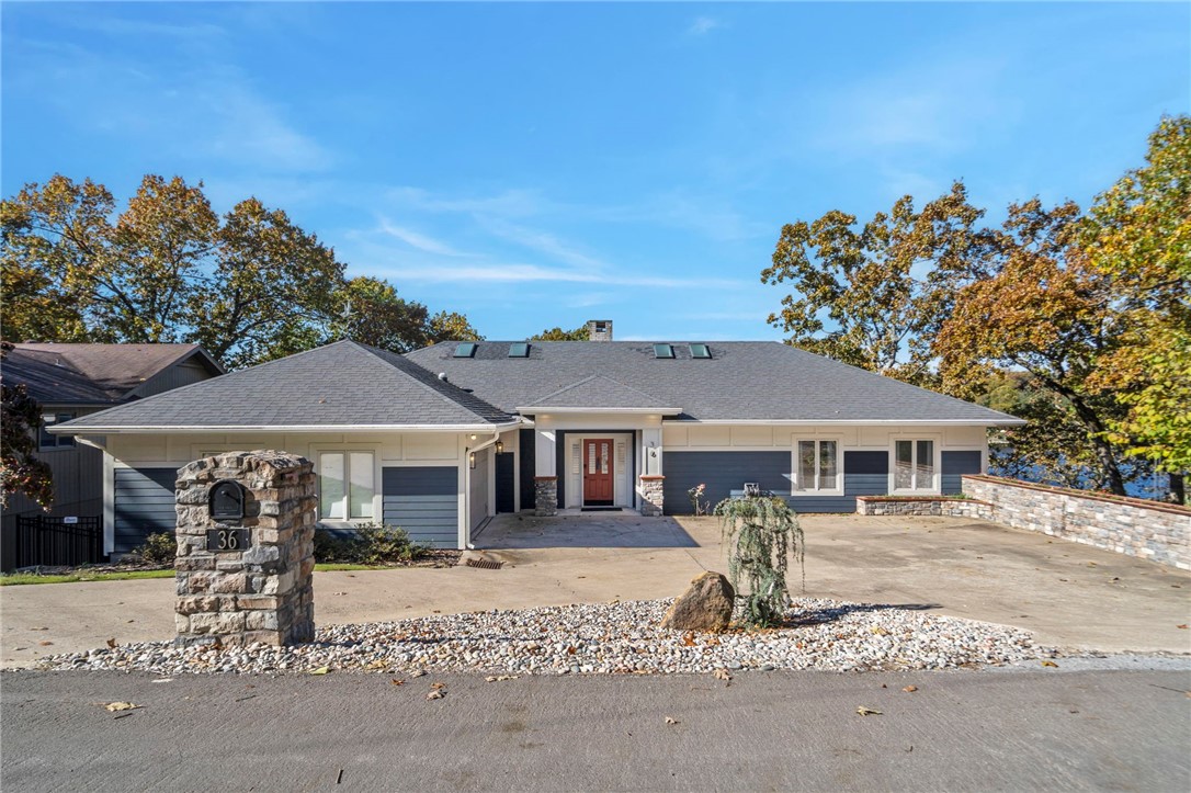 Experience resort-style living with this exceptional lakefront home on a rare DOUBLE lot on Lake Windsor! Thoughtfully updated and move-in ready, it blends timeless comfort with modern luxury, and rare drive-to-the-water convenience! The lake-level backyard allows you to drive a car or golf cart directly to the shoreline, a true Bella Vista luxury. Enjoy mornings on the deck, afternoons by your private pool, and evenings watching sunsets shimmer across the lake. Inside, fresh updates include new carpet, skylights, and new paint, creating a bright,inviting atmosphere. The open-concept living area features soaring ceilings, natural light, and panoramic lake views. A well-appointed kitchen with premium finishes connects seamlessly to dining and entertaining areas. Retreat to spacious bedrooms and spa-inspired baths, or unwind outdoors surrounded by mature trees and manicured landscaping. Minutes from I-49, downtown Bentonville and bike park, this immaculate home perfectly combines lake access, luxury, and convenience.